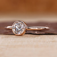 Round cut diamond ring with secure bezel solitaire setting.