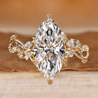 Marquise cut ring with marquise and round side stones and nature inspired style.