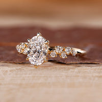 Handmade oval diamond ring with detailed cluster design.