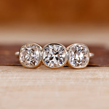 Three stone ring with cushion old european cut diamond center.