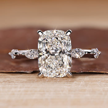 Elongated cushion cut diamond ring with distance pave setting and hidden halo.
