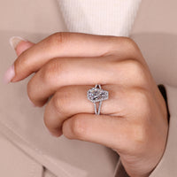 Coffin center stone ring with round diamond halo and pave accents.