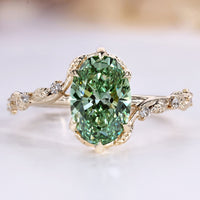 Green oval engagement ring with round side stones.