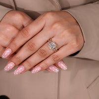 Radiant diamond ring with halo and marquise side stone accents.