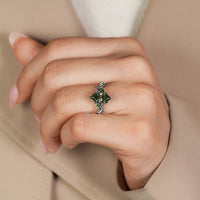 Six leaf style prong setting secures the green center stone.