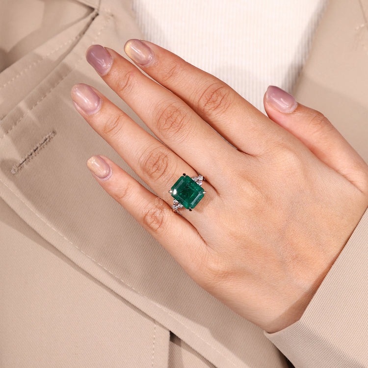 4 claw prong ring with green emerald center stone.