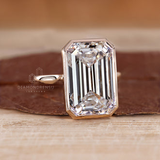 Custom diamond ring with bezel set emerald cut.