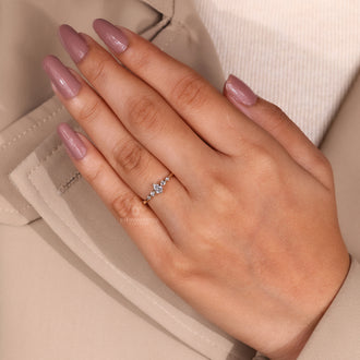 Lab grown diamond engagement ring with pear cut center and round cut sides.