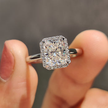 Radiant cut moissanite engagement ring with a sparkling halo design.