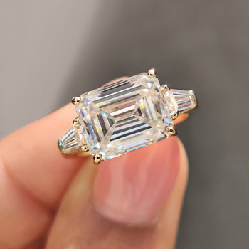 Emerald Cut Moissanite Ring with tapered baguette accents in a yellow gold setting.