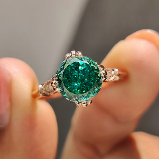 Cathedral setting ring with dark green center stone and rose gold band.