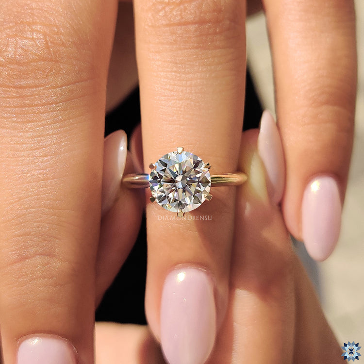 Moissanite engagement ring featuring a round cut stone, offering brilliance and shine with an eco-friendly alternative.