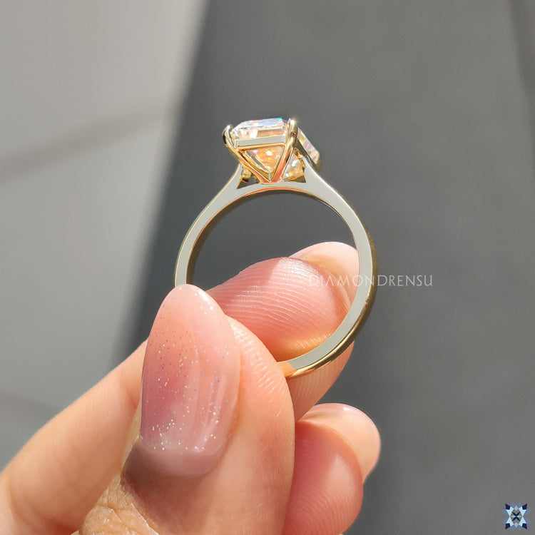 Four claw prong setting ring, securing the emerald cut moissanite stone with stability and style.