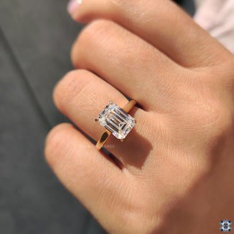 Cathedral setting engagement ring with an emerald cut stone, exuding timeless elegance and grace.
