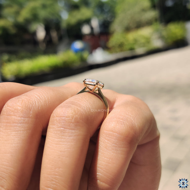 Yellow gold engagement ring with an emerald cut moissanite stone, offering a classic and warm design.