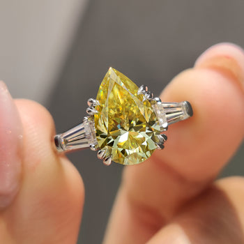 Pear three stone engagement ring with tapered baguette side stones.