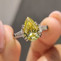 Pear three stone engagement ring with tapered baguette side stones.