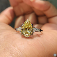 Custom engagement ring with double claw prong and pear center stone.