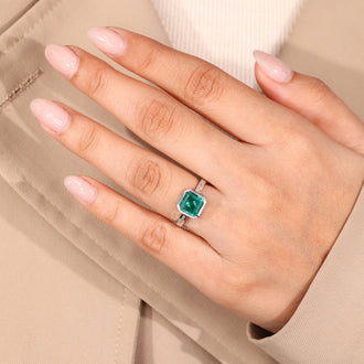 Channel setting ring with emerald center stone.