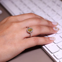 Round cut side diamonds in a halo ring with cathedral setting.