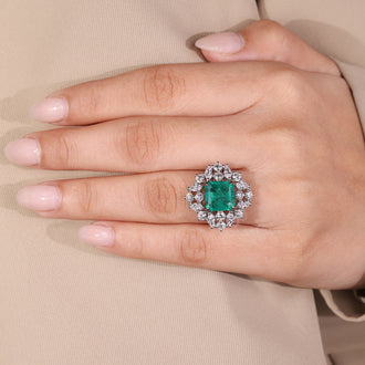 Elegant cluster halo emerald gemstone ring.