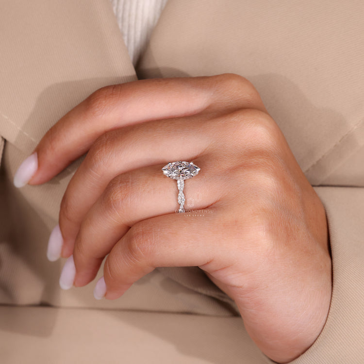Buy Engagement Ring image featuring a radiant piece on a fingertip in daylight.