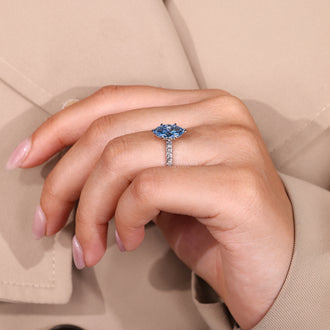 White gold ring with marquise cut blue diamond and four claw prong.