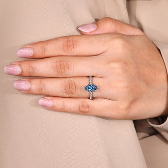 Custom diamond ring with marquise cut blue diamond and round pave band.