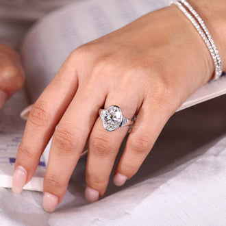 Cathedral setting ring featuring oval cut center diamond and half moon cut side stones.