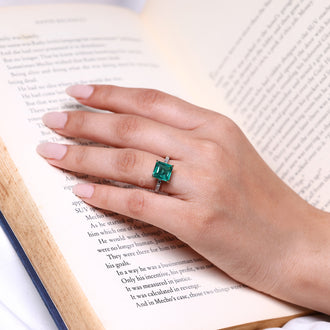 Emerald birthstone ring with diamond accents.
