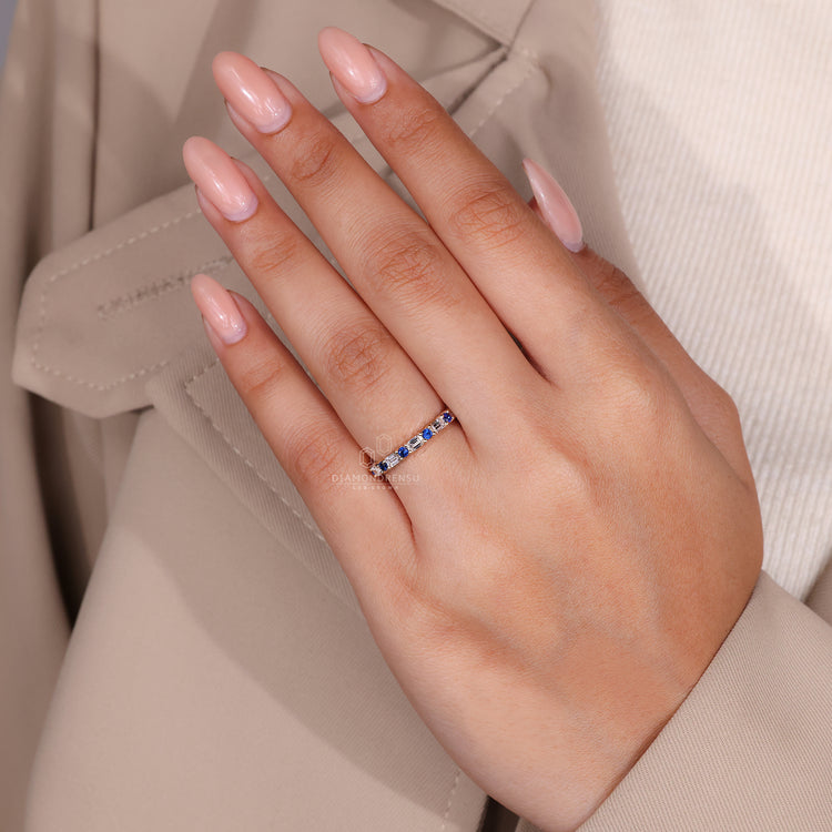 Diamondrensu wedding band with emerald and round diamonds.