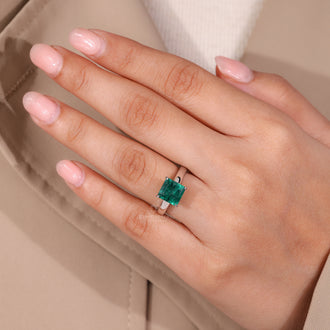 Asscher cut emerald ring in cathedral setting design.