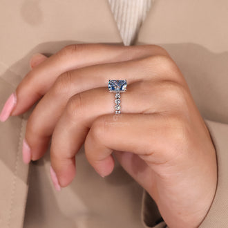 White gold diamond ring with 4 prong claw setting and blue diamond.