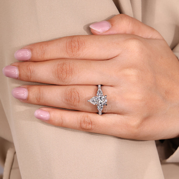 IGI certified handmade ring with pear cut diamond and round pave stones.