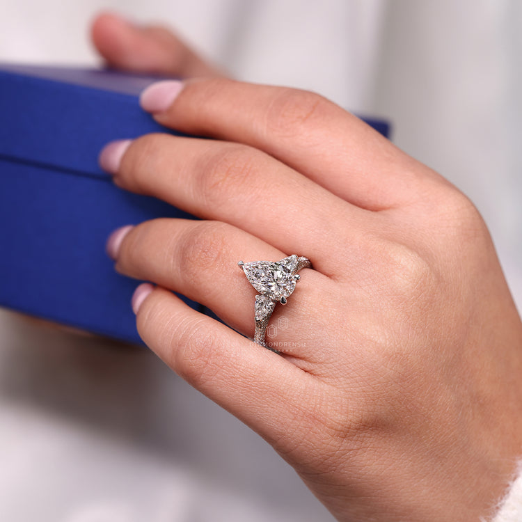 Pear side stone ring with 3 side pave setting in white gold.