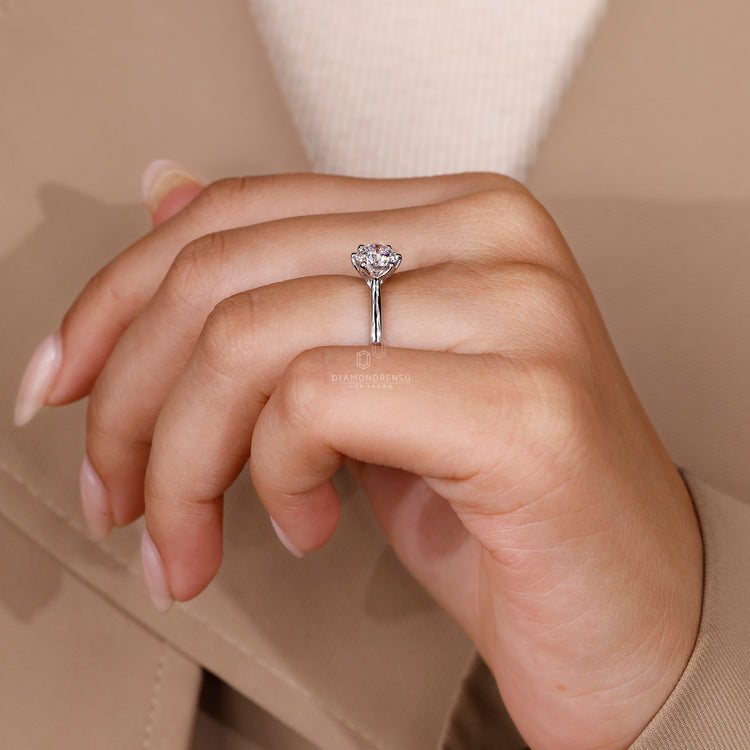 The solitaire engagement ring catches the light.