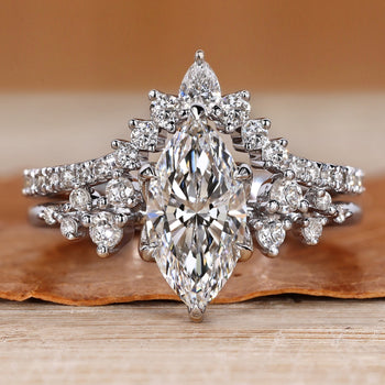 Marquise wedding ring with round side stones and prongs.