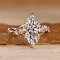 Six claw prong setting secures the marquise center stone.