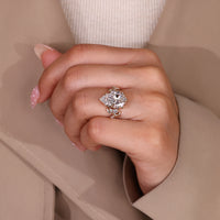 Handmade pear cut engagement ring with round side stones.