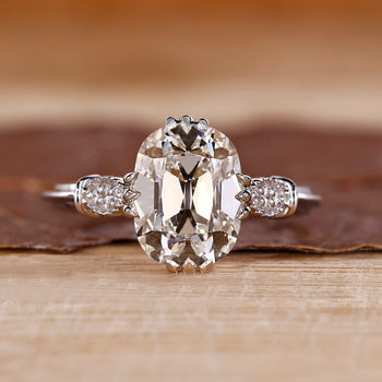 Vintage engagement ring with cushion old mine cut diamond and round sides.