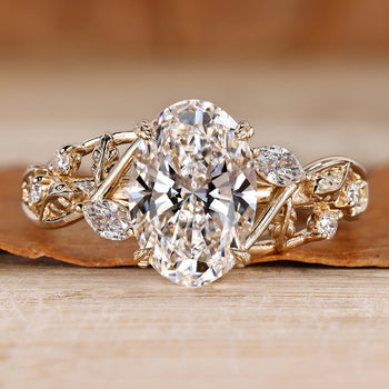 Nature inspired engagement ring with oval center stone and side stones.