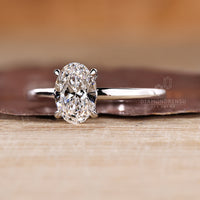 Oval diamond ring with hidden halo and solitaire design.
