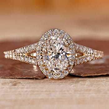 Oval diamond engagement ring with round cut halo style and split shank.