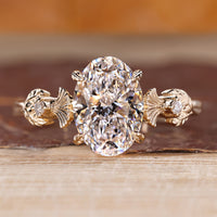 Nature inspired ring featuring oval diamond and vintage engagement design.
