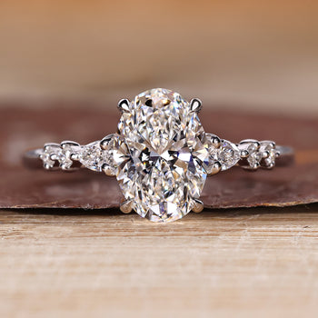 Oval cut diamond ring with seven stones including pear and round side stones.