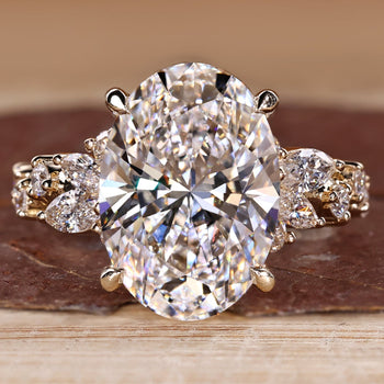 Oval diamond ring with cluster setting and side stones.