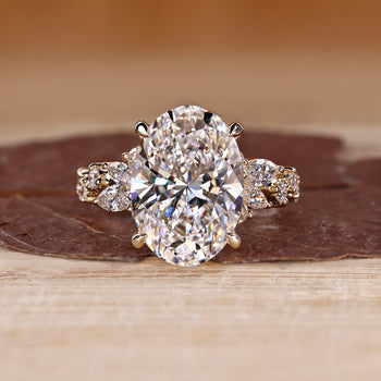 Oval diamond ring with cluster setting and side stones.