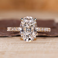 Oval cut diamond ring with round cut pave band and hidden halo setting.