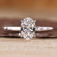 Oval diamond engagement ring with solitaire setting and round cut hidden halo.