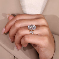 Handmade oval diamond ring with marquise and round accents.